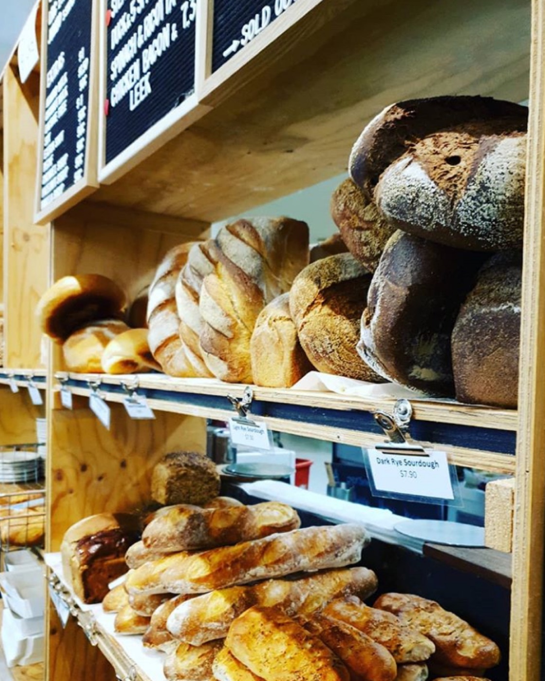 Fresh artisan loaves arranged on the bakery shelves